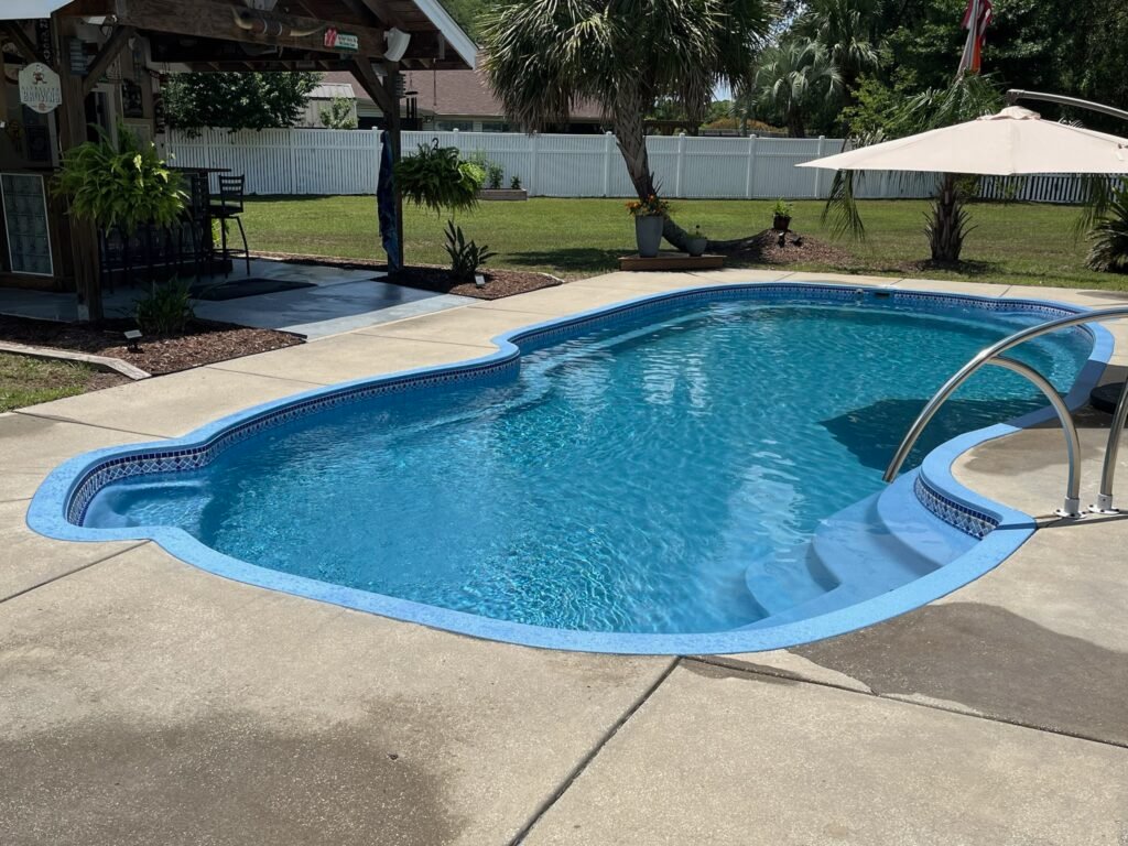 Backyard swimming pool refinished by SC Pool Resurfacing.