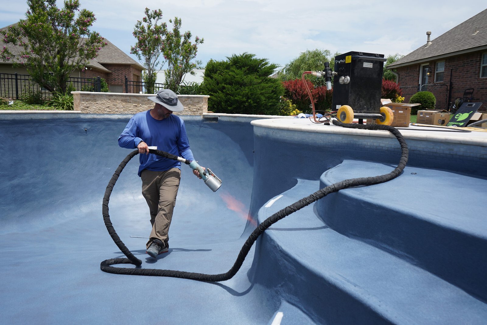 Technician resurfacing pool interior with EcoFinish system.