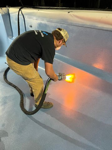 Technician applying EcoFinish pool coating during resurfacing process in Charleston SC.