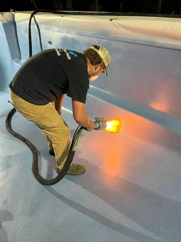 Technician applying EcoFinish pool coating during resurfacing process in Charleston SC.