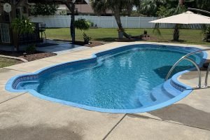 Backyard swimming pool refinished by SC Pool Resurfacing.